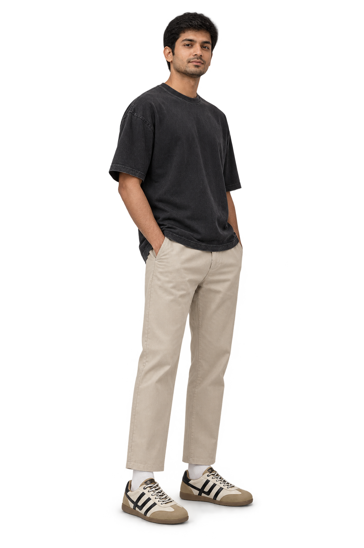 Man standing with hands in pockets wearing HOS FELIX sneakers in Beige / Cyber White with a black tee and stone trousers