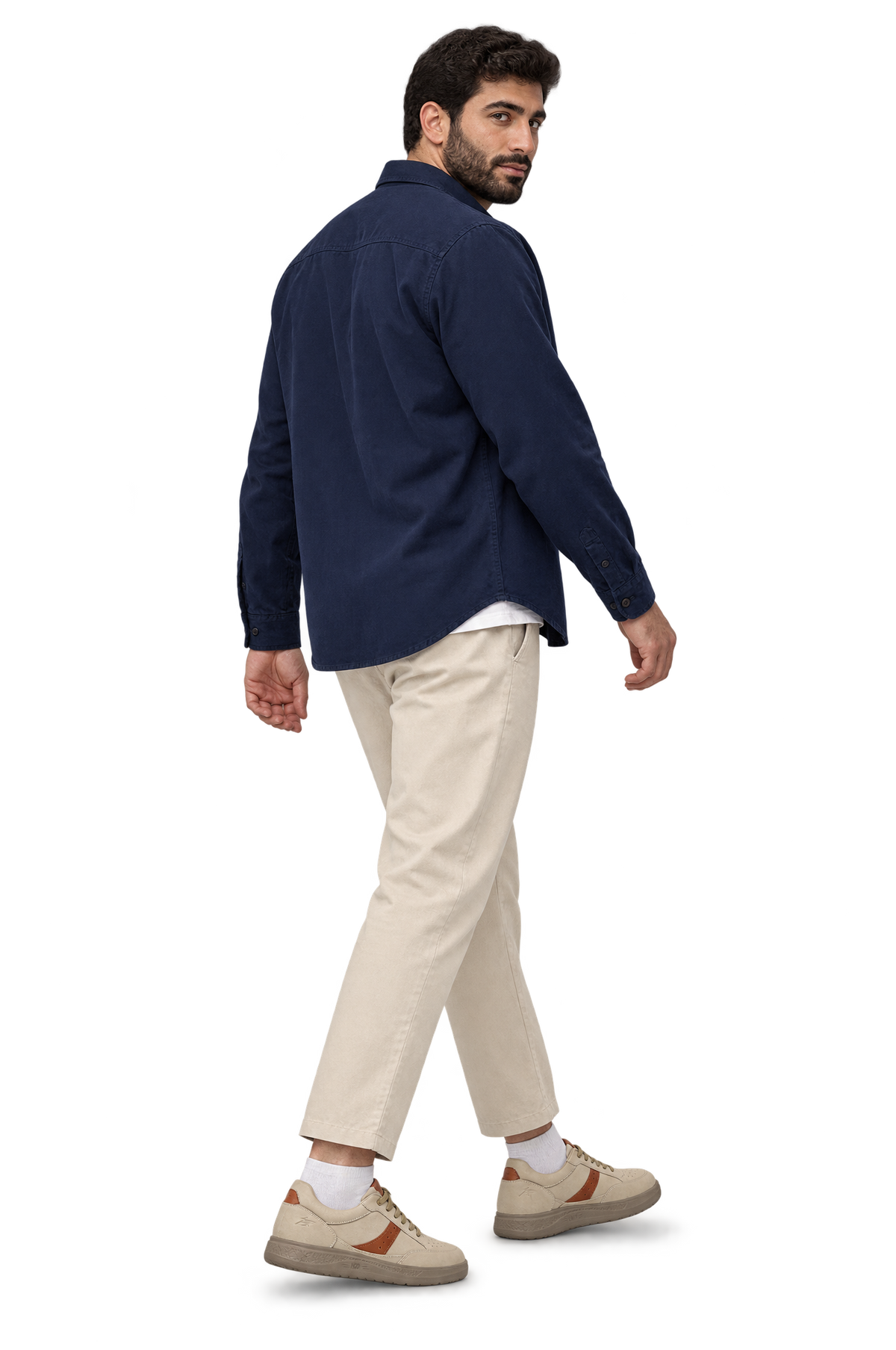 Man looking over his shoulder wearing HOS FORMA sneakers in Beige / Tan with a navy overshirt and ecru chinos