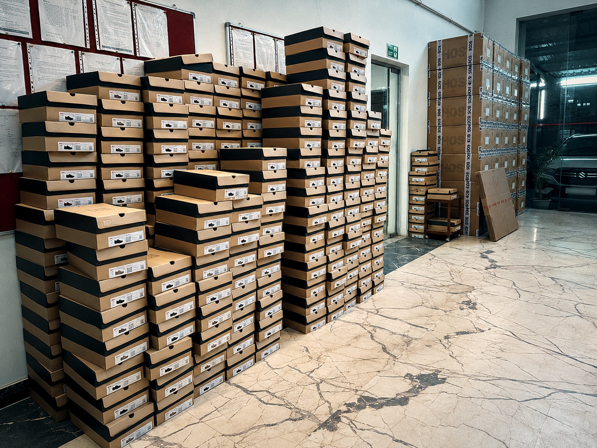 Stacks of boxed HOS sneakers in our stock room, ready to ship